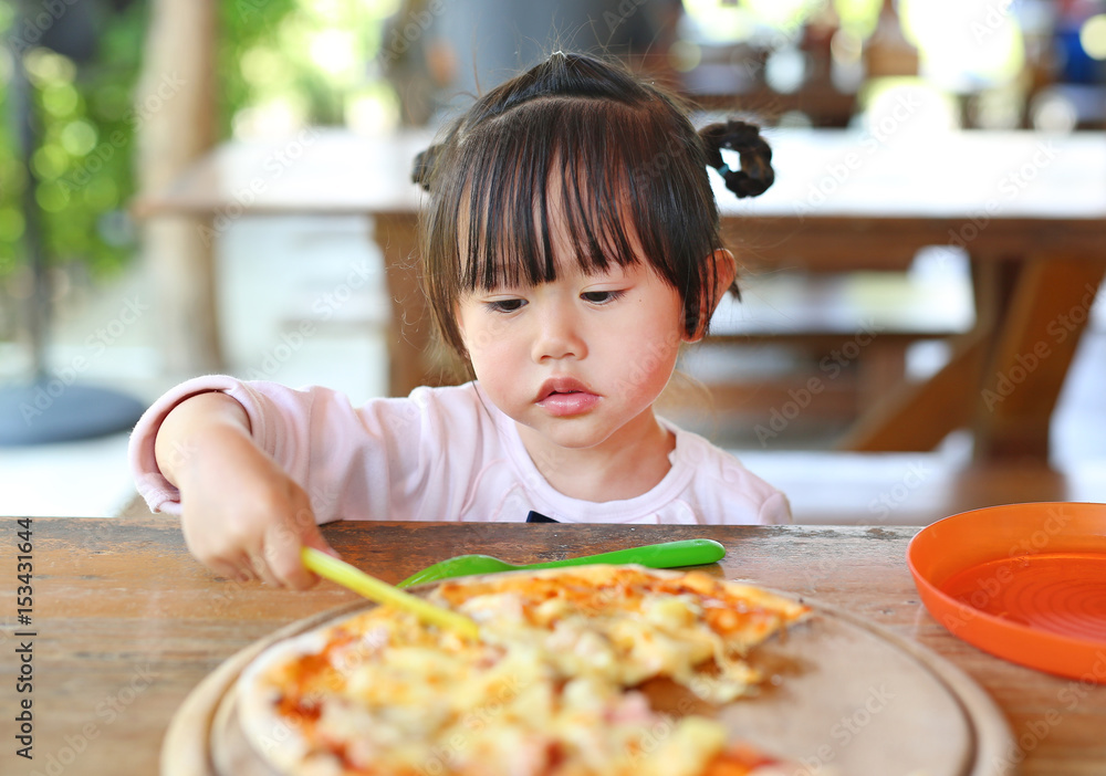 Little child girl enjoy eating pizza.