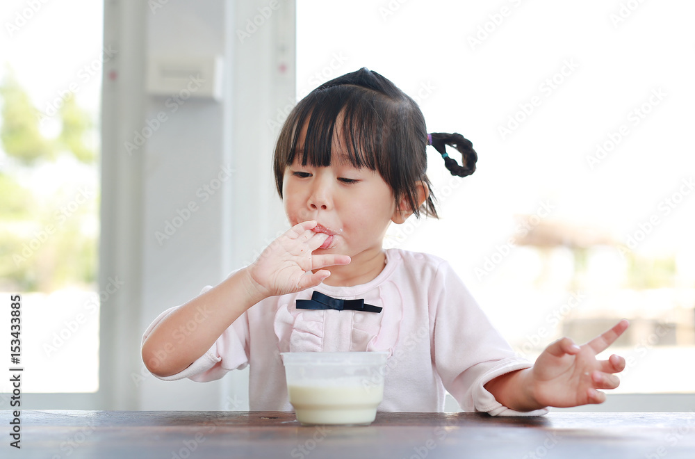 Little child girl eating and tasting ice cream, Child girl licking her fingers. Little child girl eating and tasting ice cream, Child girl licking her fingers.