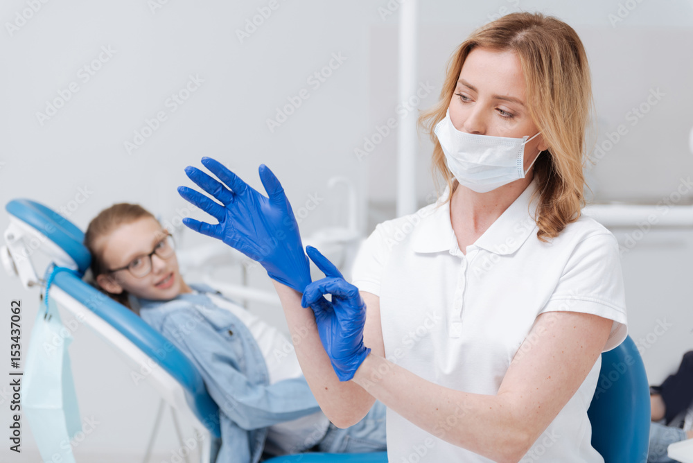 Trained mindful dentist putting on her uniform