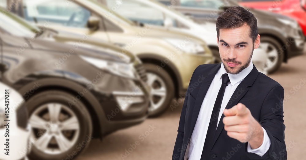 Businessman pointing against car in showroom Businessman pointing against car in showroom