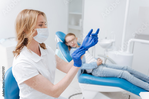 Precise delicate dentist preparing for procedure