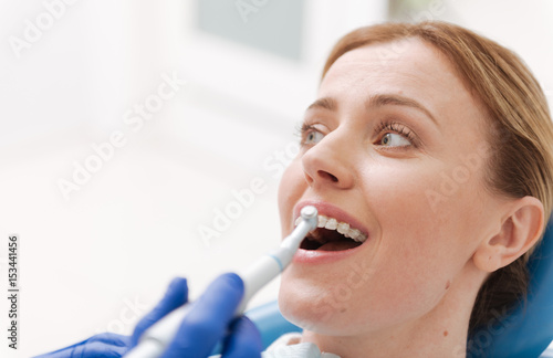 Sweet emotional woman sitting in dentists chair