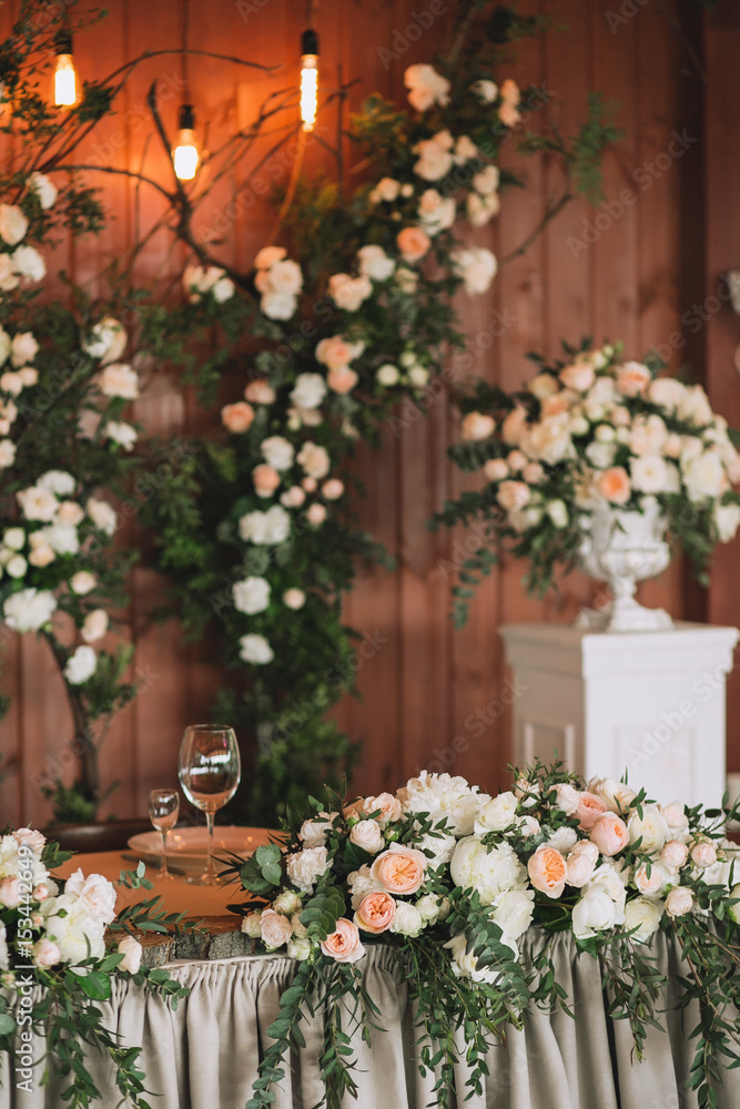 Wedding table served banquet decorated with flowers and plants, retro lamps on a wooden background