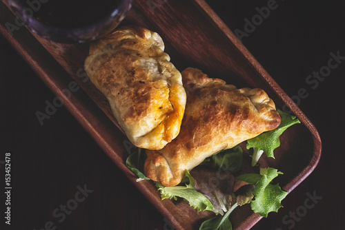 Two lamb stuffed empanadas and a glass of red local wine in a patagonia argentina chic retreat.