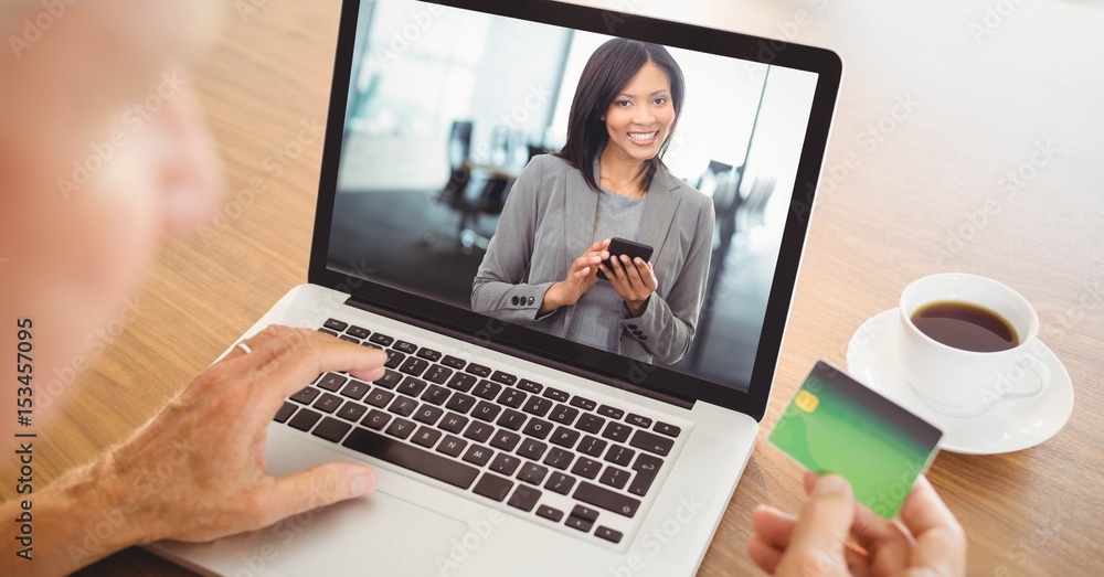 Person using card while video conferencing with businesswoman on laptop Person using card while video conferencing with businesswoman on laptop