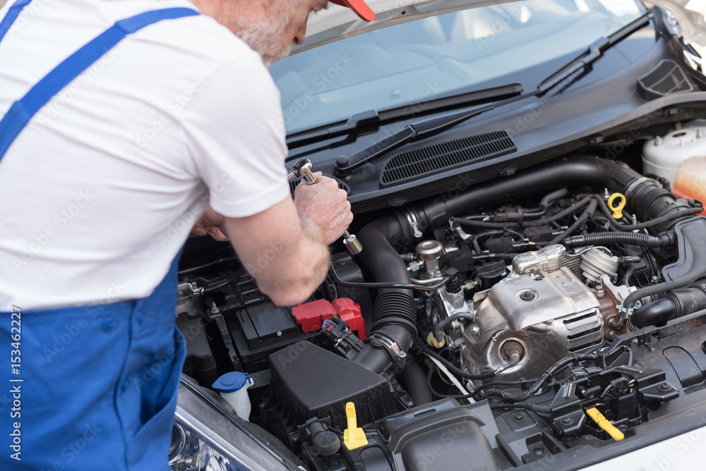 Car mechanic working on car engine Car mechanic working on car engine