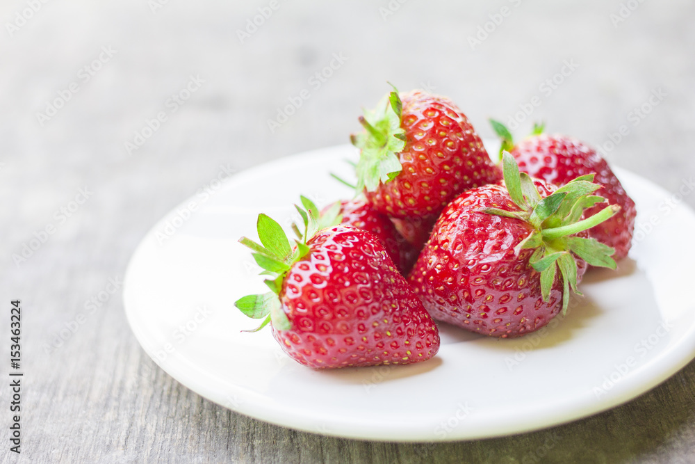 strawberry in a dish placed on the wood strawberry in a dish placed on the wood