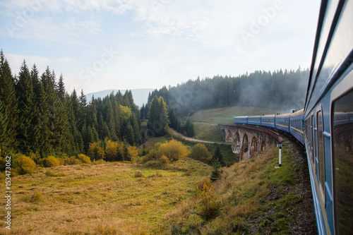 View from the train window at the sunlit village. Carpathians, Ukraine