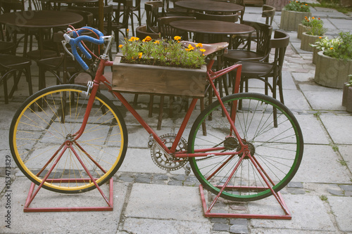 Vintage stylized photo of Old bicycle carrying flowers as decoration