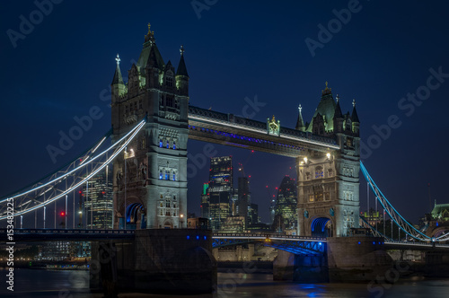 Tower bridge at night and the skyscrapers of the City of London in the background in England, UK