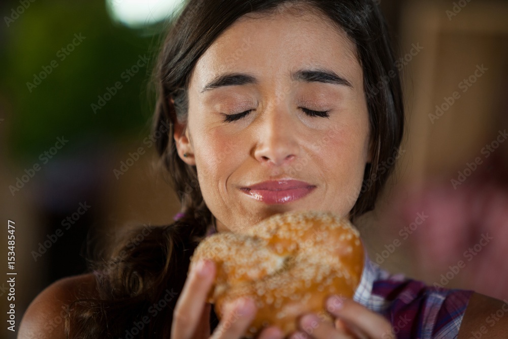 Smiling woman smelling a bread at counter Smiling woman smelling a bread at counter