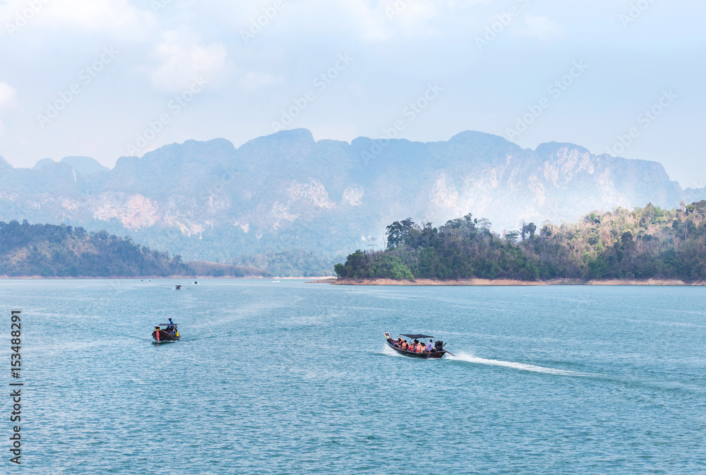 Fototapeta premium longtail boats sailing in lake of ratchaprapha dam at khao sok national park, Surat Thani province,Thailand