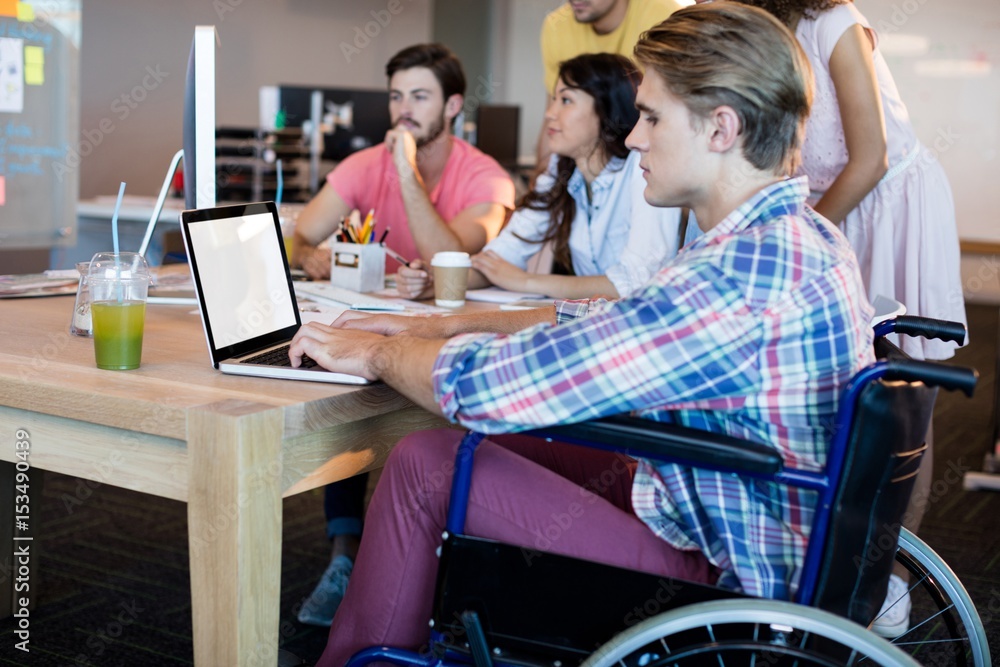 Man using laptop while working with his team Man using laptop while working with his team