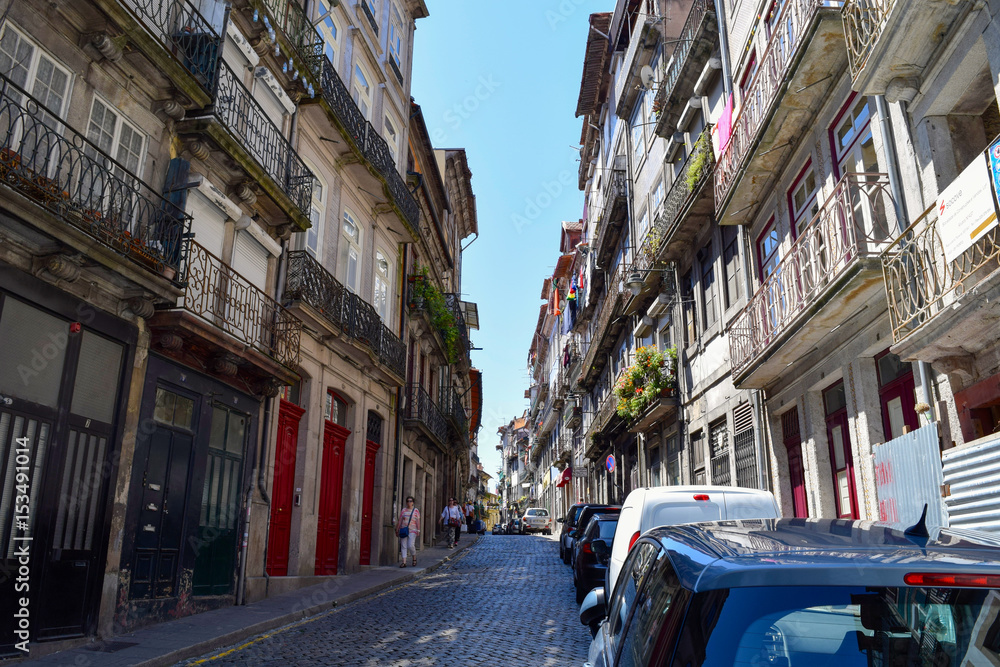 Unidentified people walk through the narrow streets of Ribeira in Porto, Portugal