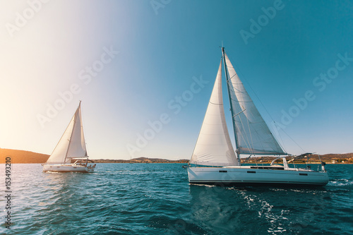 Sailing yachts at the Aegean Sea at sunset. Luxury boats.