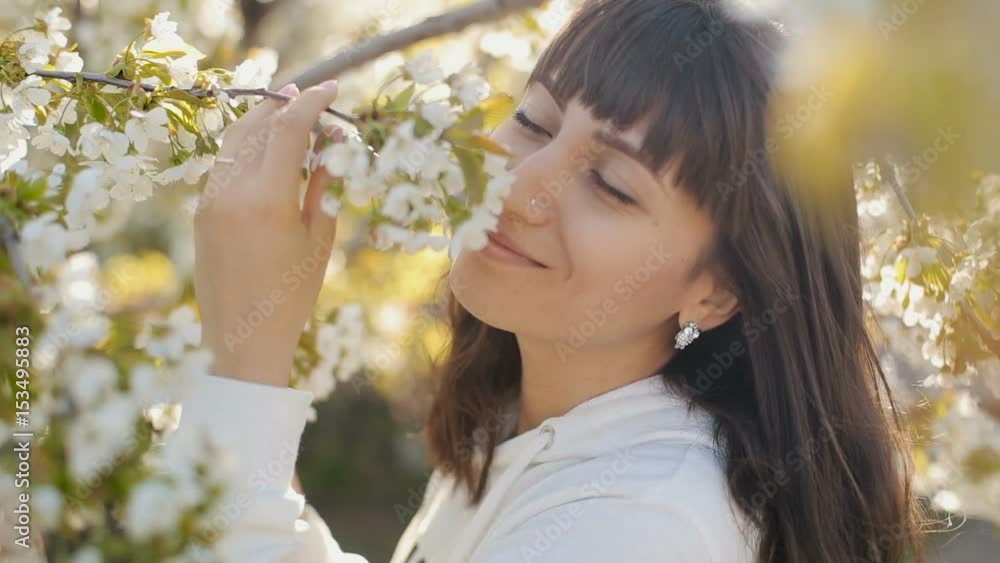 Woman smelling white flowers in springtime Woman smelling white flowers in springtime