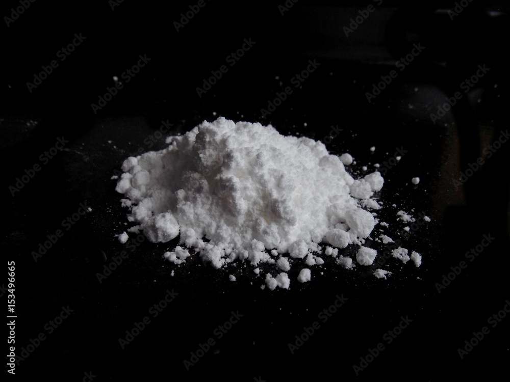 Cocaine drug powder pile on black background