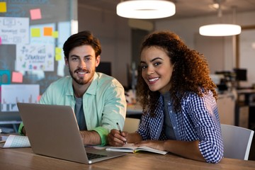 Smiling creative business people with laptop 