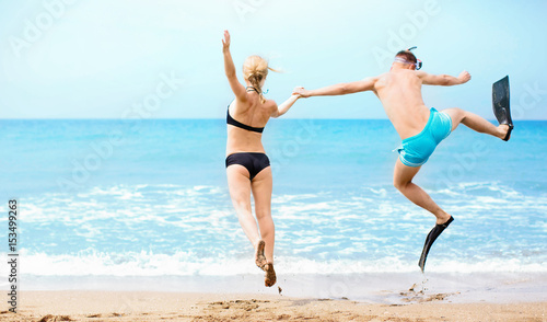 Happy couple jumping in the sea