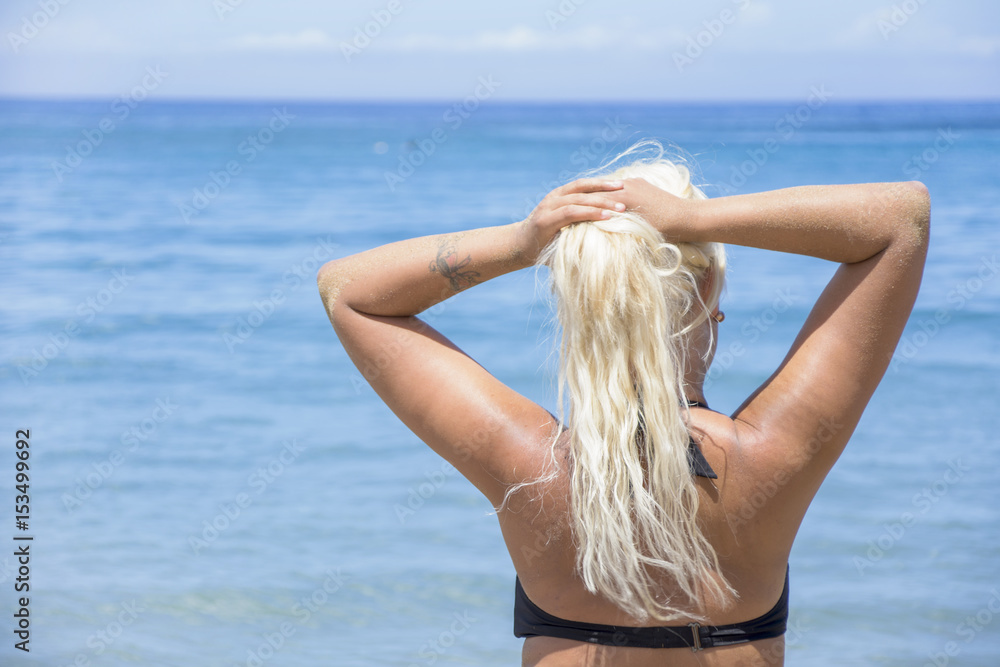 The blonde woman decides to relax in the sea of the beach during its holidays. The blonde woman decides to relax in the sea of the beach during its holidays.