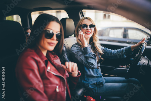 Two young women friends talking together in the o car as they go on a road trip driver speak on phone © F8  \ Suport Ukraine