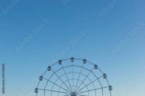 Ferris wheel against blue sky background