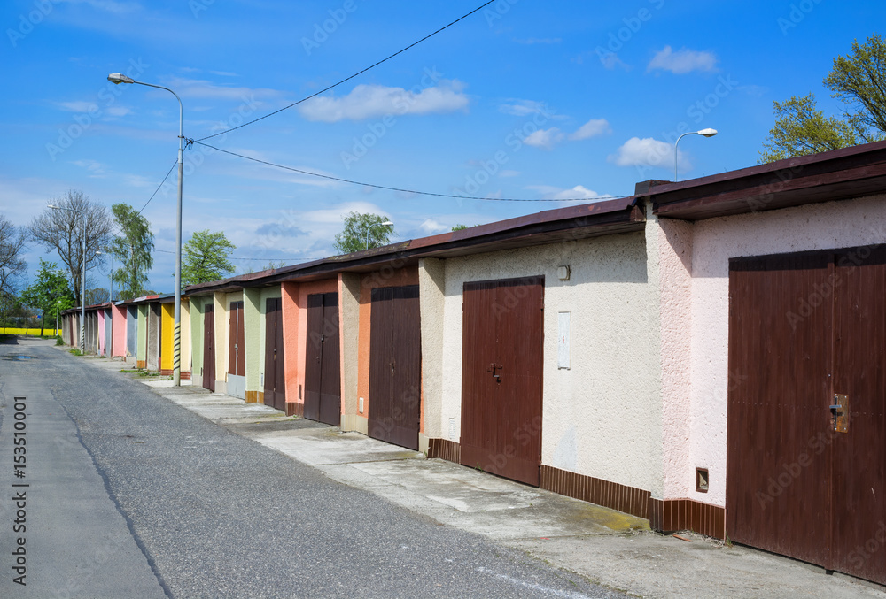 Row and line of garages for cars. Building for covering and protection of cars, automobiles and vehicles. Doors are closed. Row and line of garages for cars. Building for covering and protection of cars, automobiles and vehicles. Doors are closed.