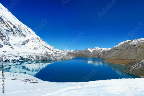 Tilicho Lake in Annapurna Conservation Area, Nepal. Mountains reflecting in the water of the lake. photo