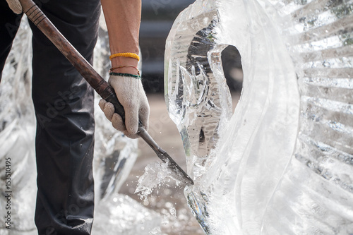 man is carving the ice sculpture for wedding