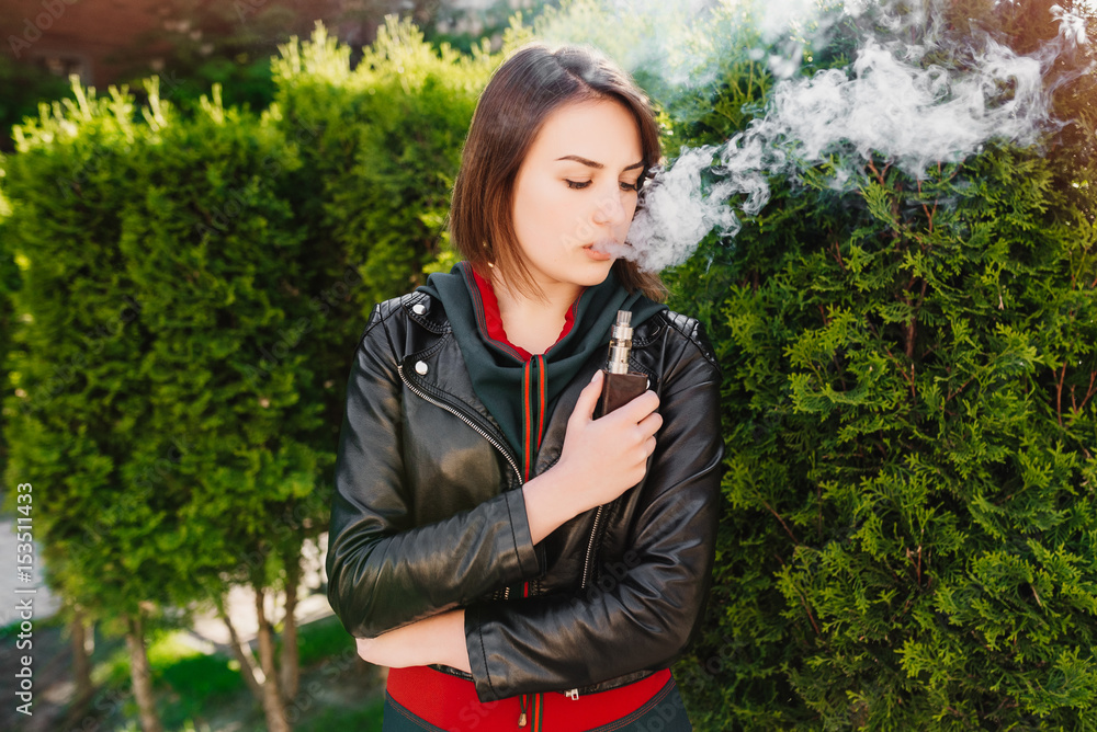 Portrait of a beautiful young girl with vape. Vaping concept Portrait of a beautiful young girl with vape. Vaping concept