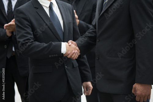 Businessmen handshaking after striking grand deal.