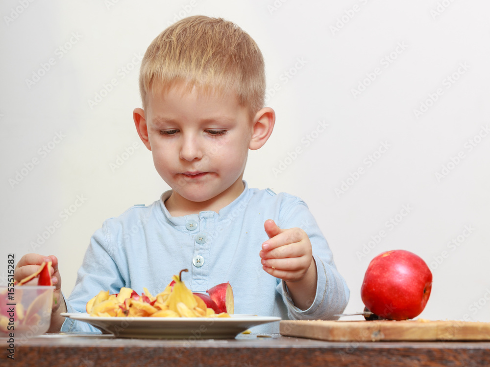 Little boy peeling apples with knife and eating Little boy peeling apples with knife and eating