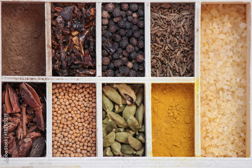 Spices in a box (set): cinnamon, baden, turmeric, mustard, cardamom, paprika, pepper, cumin, salt © Alesia Berlezova