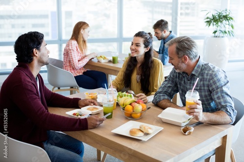 Creative business team discussing while having meal photo