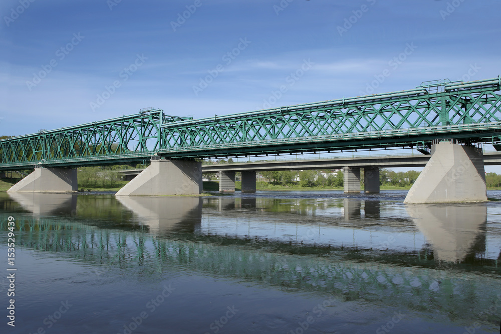 Railway bridge and road bridge over the river. Kaunas, Lithuania – May 17, 2017: Green Railway Bridge and  M. K. Ciurlionis Bridge crosses Nemunas river.