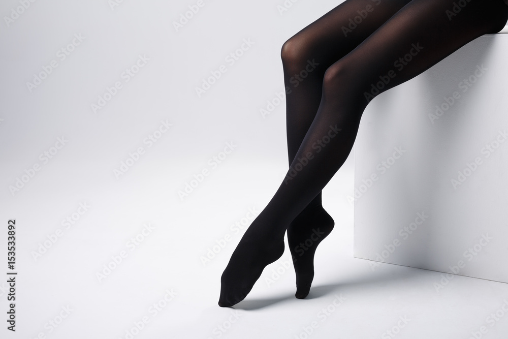 Slim sexy female long legs in black pantyhose on studio box. foto de Stock  | Adobe Stock