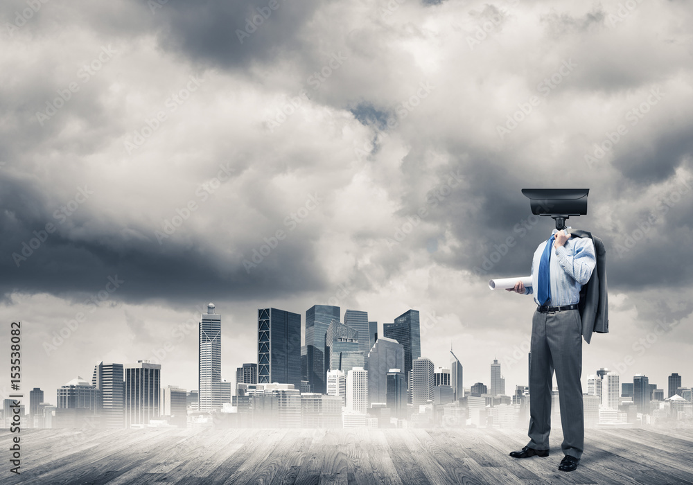 Camera headed man standing on wooden floor against modern citysc Camera headed man standing on wooden floor against modern citysc