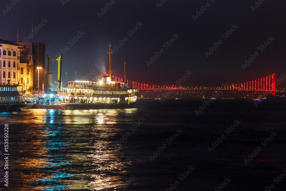 View of Galata quarter on the Bosporus and a bridge in the distance at night. Istanbul. Turkey.