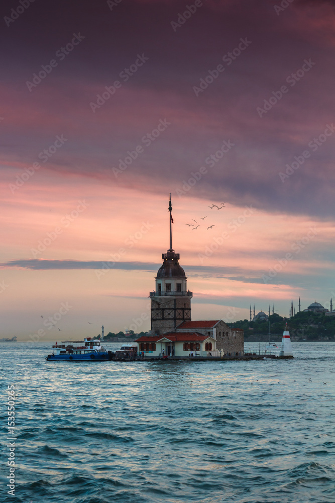 Beautiful landscape of Maiden's tower (Tower of Leandros) at sunset. Dramatic cloudy sky. In the distance are such landmarks as Hagia Sophia, Blue Mosque and Topkapi Palace. Istanbul. Turkey. Beautiful landscape of Maiden's tower (Tower of Leandros) at sunset. Dramatic cloudy sky. In the distance are such landmarks as Hagia Sophia, Blue Mosque and Topkapi Palace. Istanbul. Turkey.
