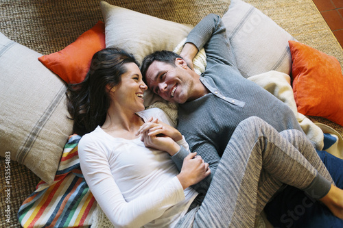 High angle view of affectionate couple lying on carpet at home