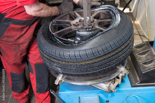 Mann montiert neuen Reifen auf einer Felge in der Werkstatt