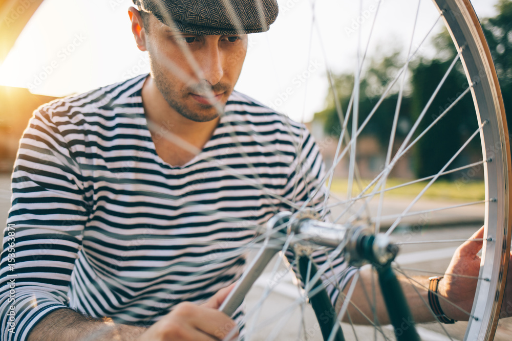 Bicycle mechanic reparing bicycle wheel
