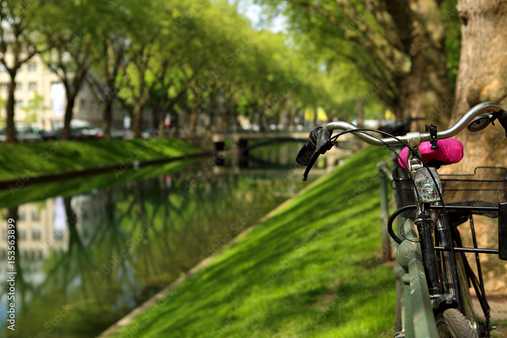 Bicycle in the park near the river on bright sunny summer green background Bicycle in the park near the river on bright sunny summer green background
