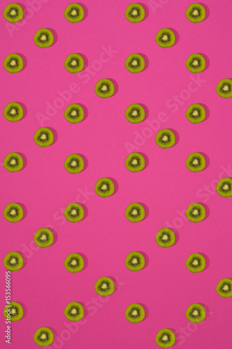 Pattern of kiwi. Top view of the sliced kiwi on pink background. Minimal flat lay concept.