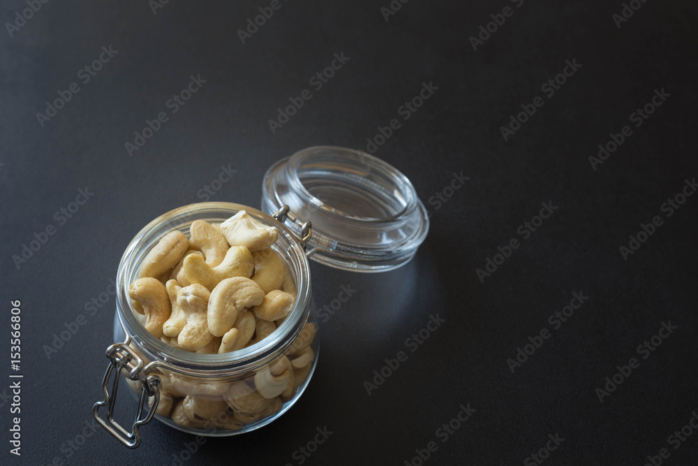 Cashew nuts in a jar on the dark stone table background. Cashew nuts in a jar on the dark stone table background.
