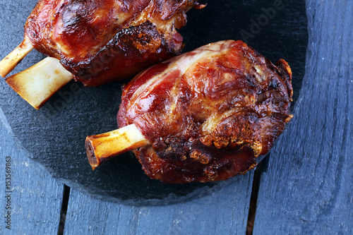 Canvas Print Smoked ham hock with herbs and spices on wooden plate.