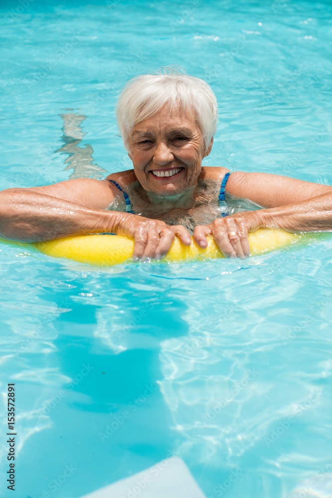 Senior woman swimming with inflatable tube