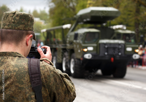 Army journalist photographer. Soldier takes picture military vehicle