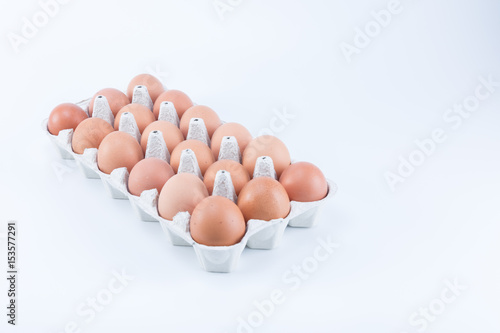 Big large tray of brown eggs isolated on white background. Eighteen eggs.