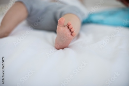 Close-up of baby girl feet relaxing on bed
